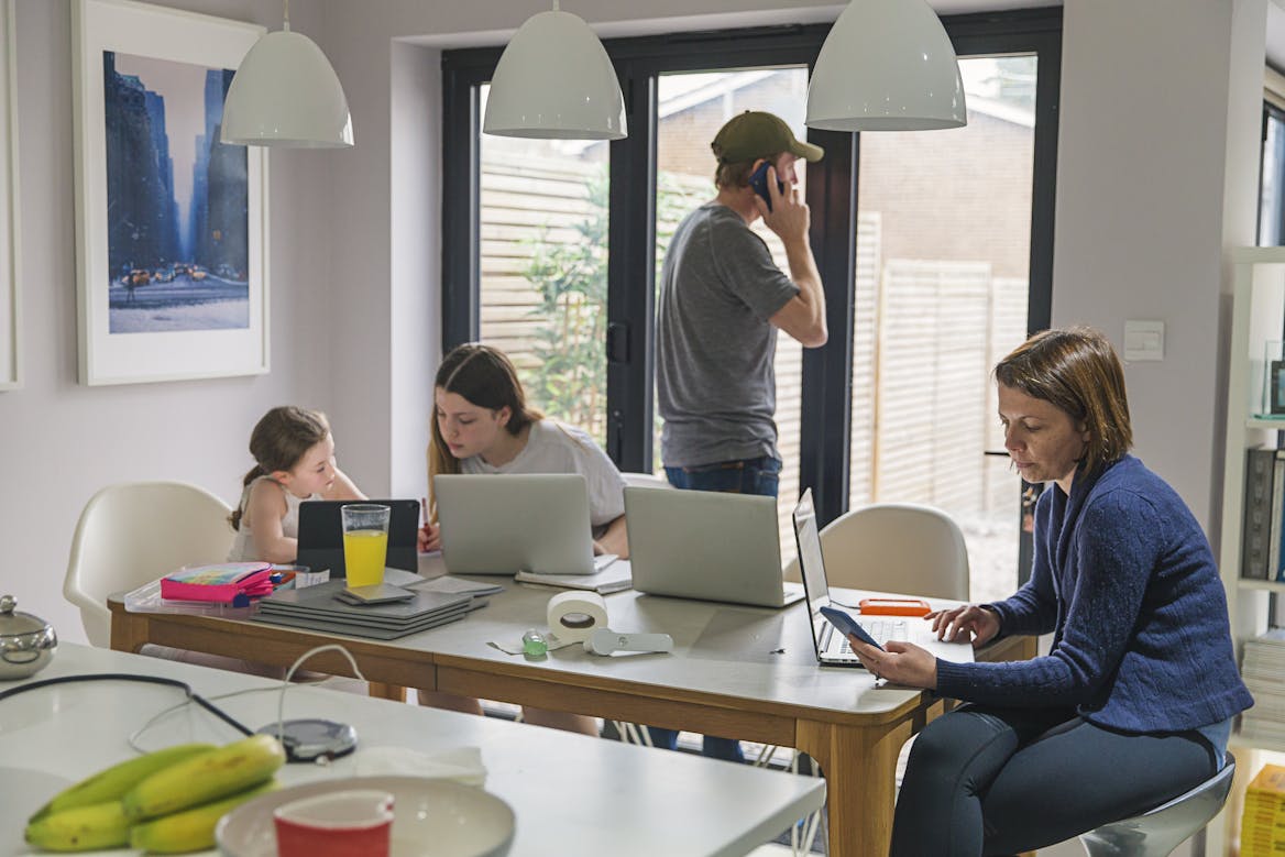 family on laptops around dining table family on laptops around dining table
