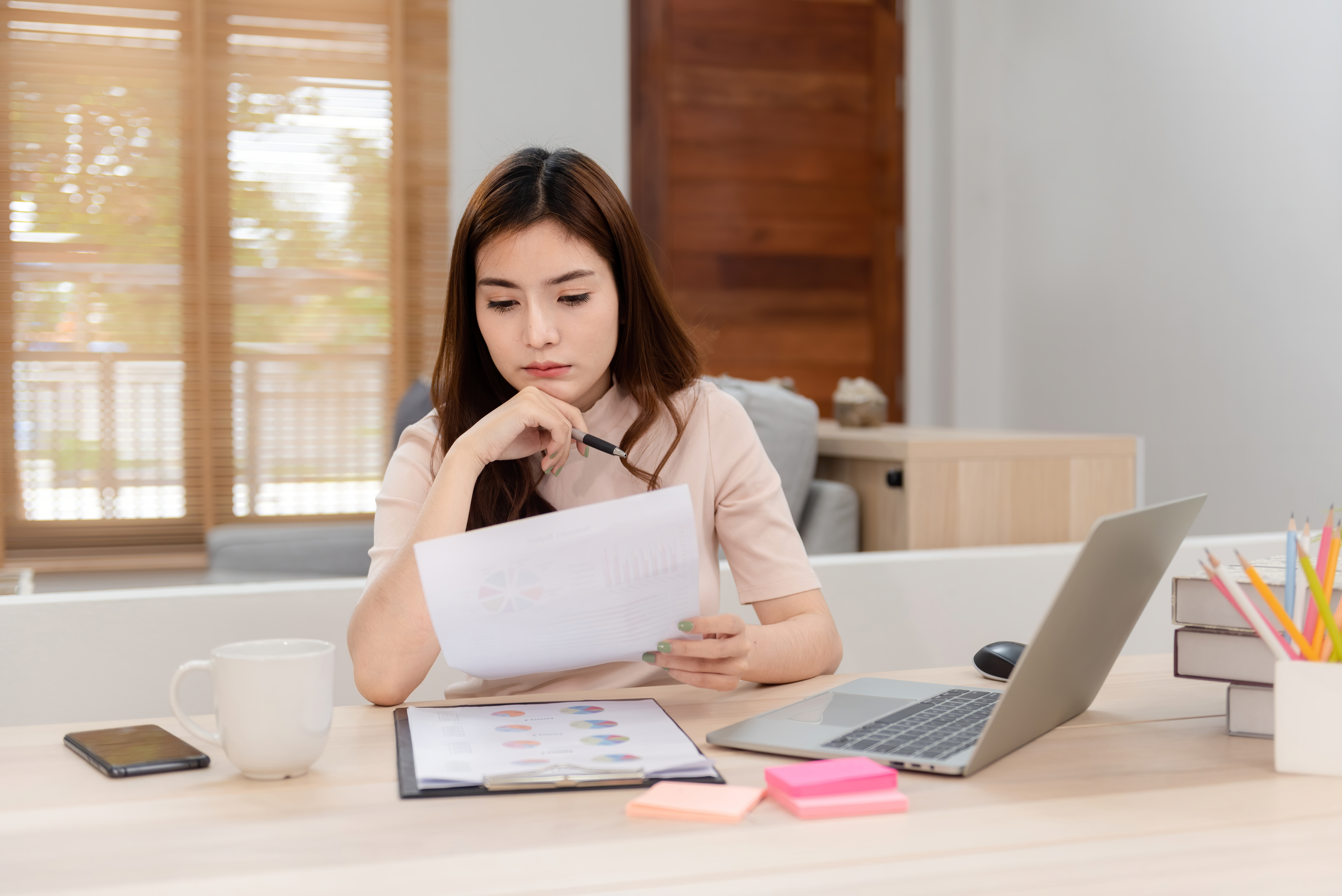 Woman at desk reviewing sheets