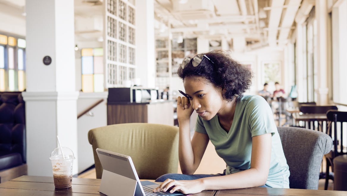 Person studying in a library with laptop Person studying in a library with laptop