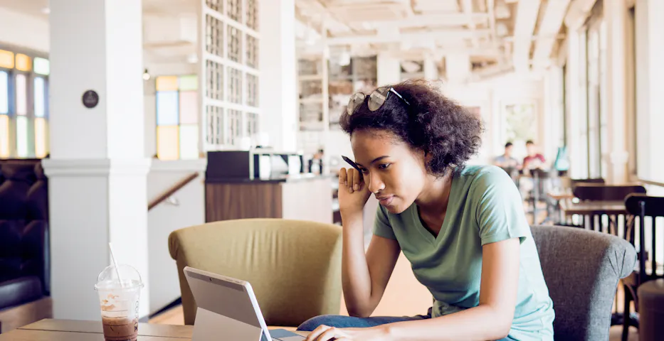 Person studying in a library with laptop Person studying in a library with laptop