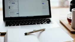a notebook and pen in front of a laptop a notebook and pen in front of a laptop