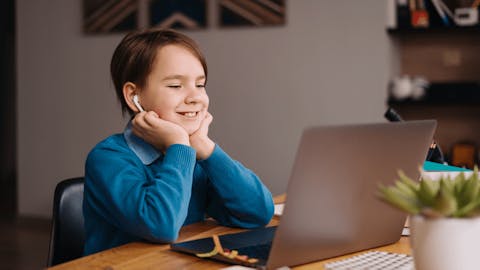 school-aged child engaged in small group learning at a laptop school-aged child engaged in small group learning at a laptop