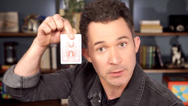Justin Willman holding a card