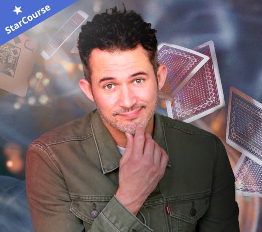 Justin Willman in front of cards, smoke, and sparks Justin Willman in front of cards, smoke, and sparks