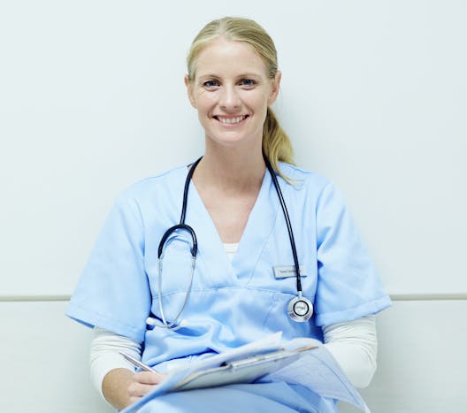 a nurse sitting and smiling a nurse sitting and smiling