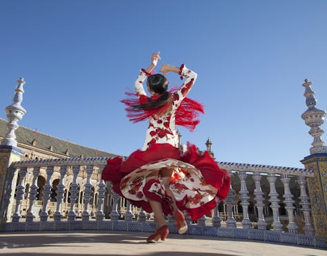 跳舞在红色和白色礼服的西班牙妇女