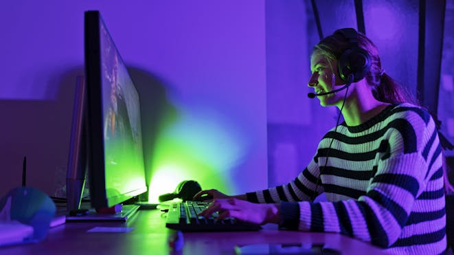 Girl playing games on desktop with headset