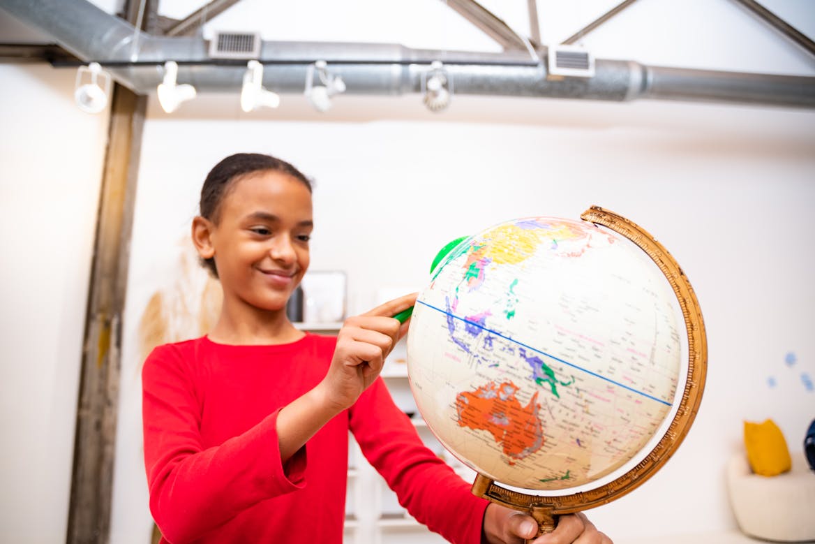 girl wearing red spinning a globe girl wearing red spinning a globe