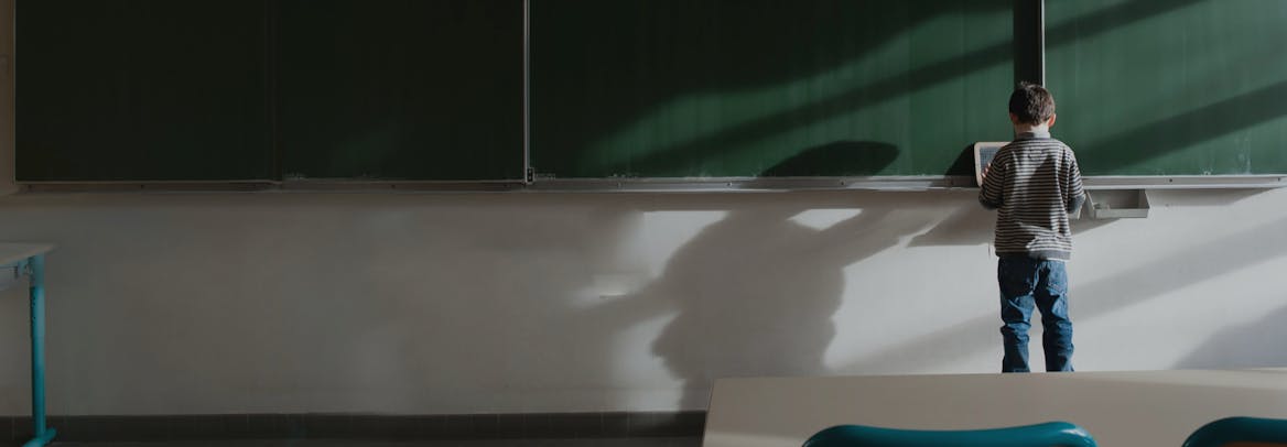 A lonely child in an empty classroom A lonely child in an empty classroom