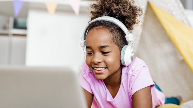 Girl wearing headphones on laptop